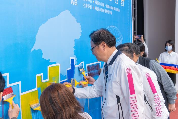 張市長與貴賓手持油漆刷進行彩繪