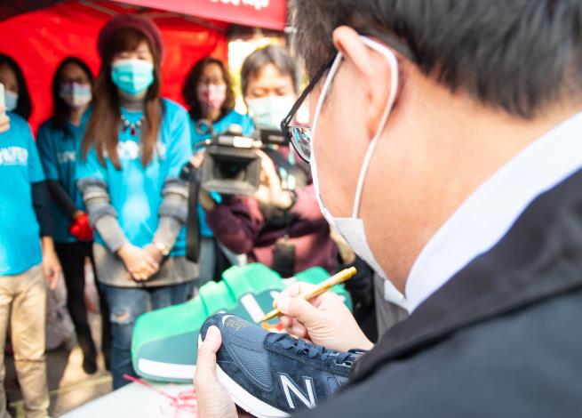 市長在捐贈的運動鞋上簽名