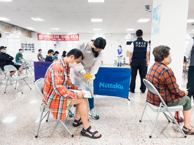 醫護人員向民眾確認接種資料