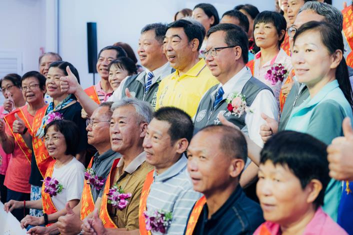 市長與敬老楷模合影，並肯定長者們在退休後，仍照顧社區，展現樂在志工的精神