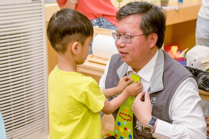 小朋友幫市長裝上紙領帶