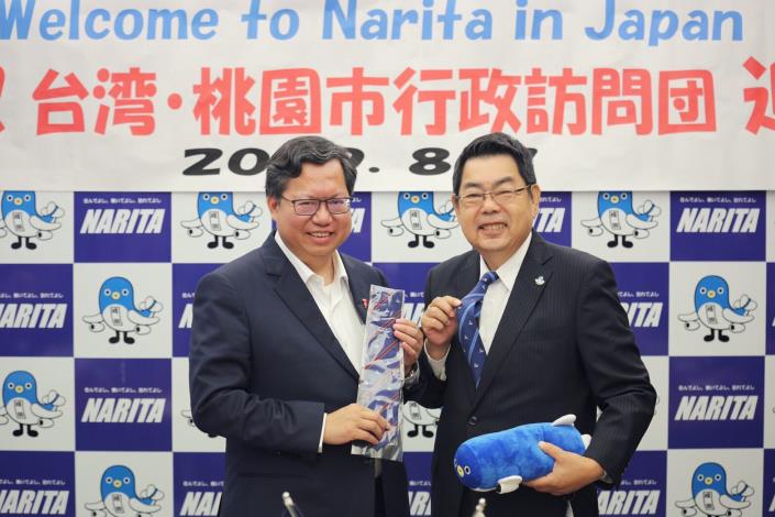 成田市致贈官方吉祥物鰻成君造型領帶及靠枕紀念品