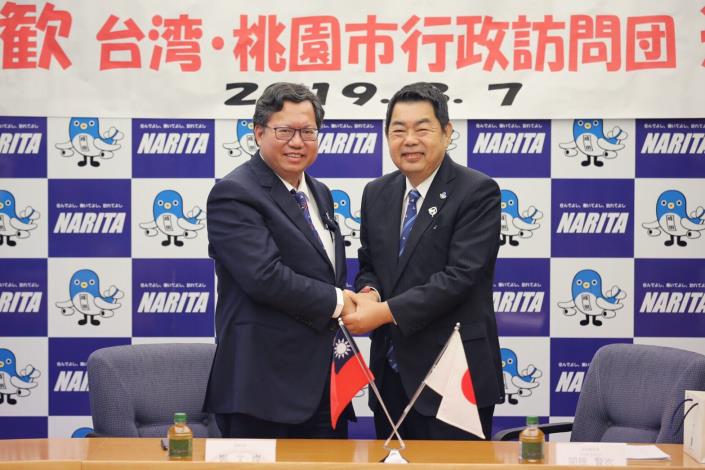 鄭市長與成田市副市長握手合影