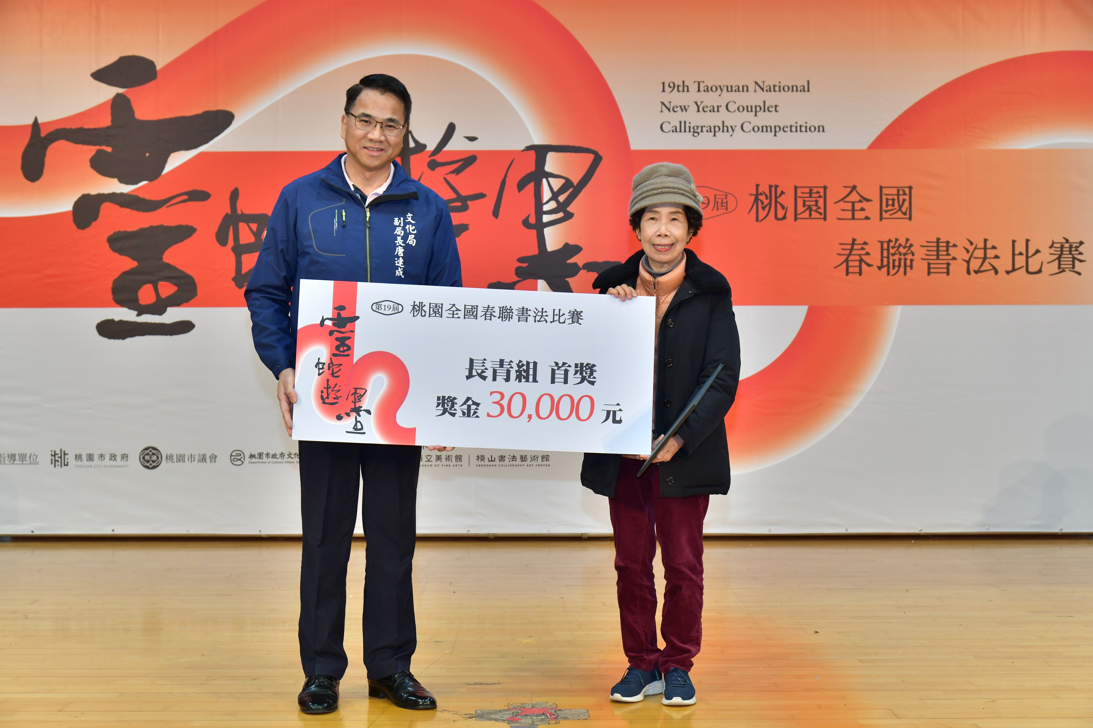 11-「靈蛇遊墨 第19屆桃園全國春聯書法比賽」頒獎典禮由桃園市文化局副局長唐連成頒發長青組首獎林杏嬌.JPG