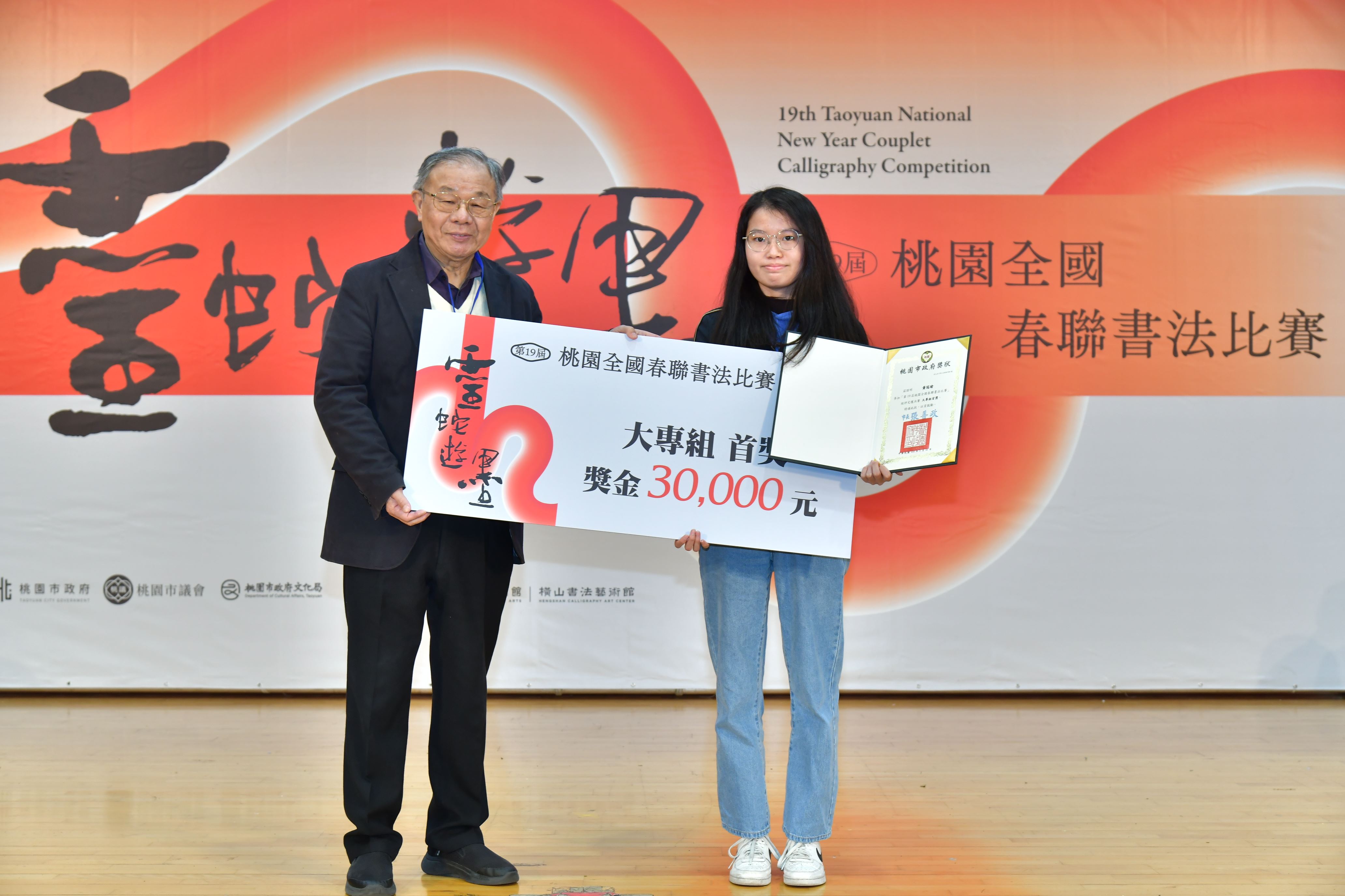 12-「靈蛇遊墨 第19屆桃園全國春聯書法比賽」頒獎典禮由評審委員張炳煌頒發大專組首獎黃冠瑜.JPG