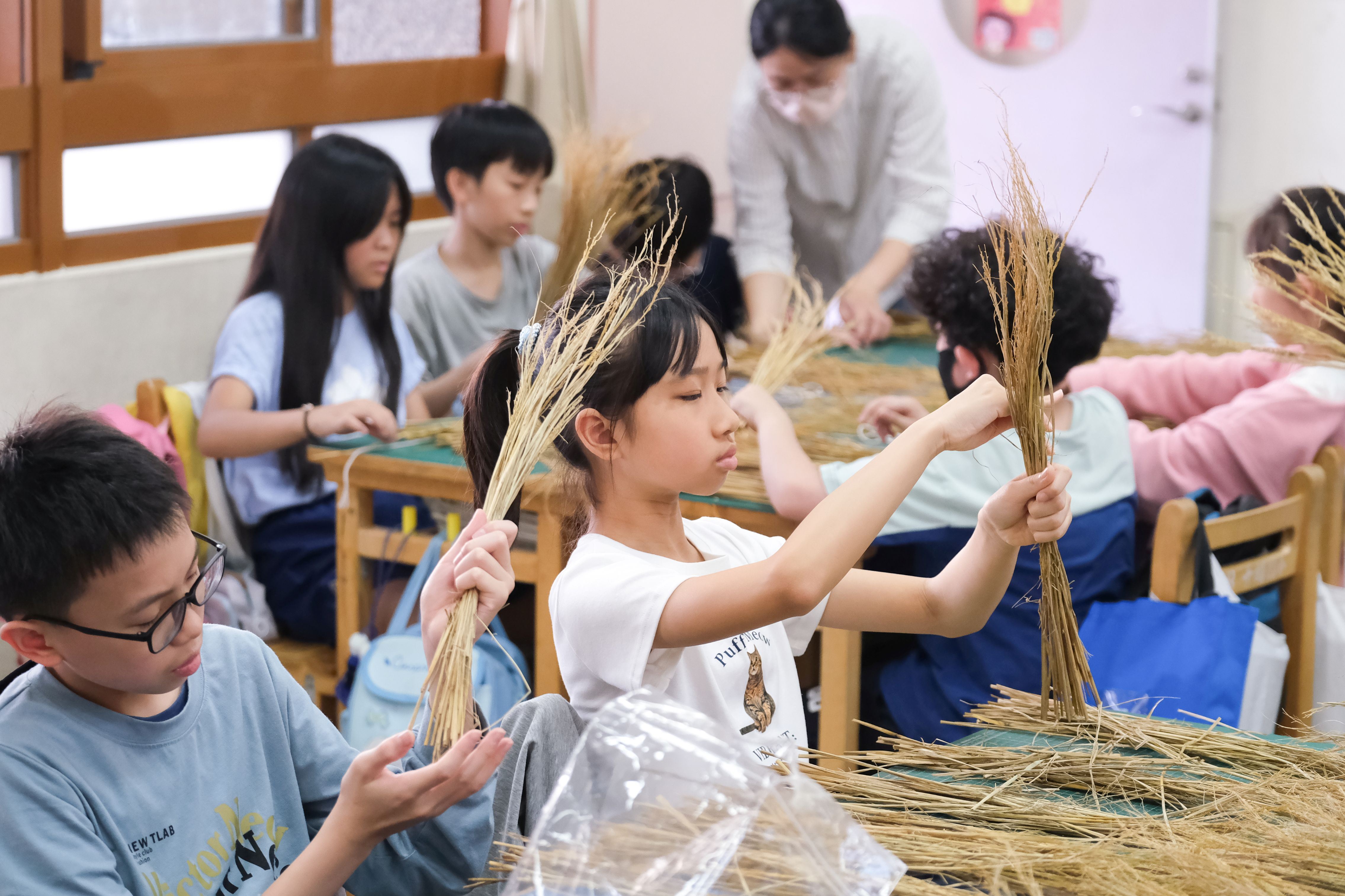 3學童運用稻殼製作掃把。(透島影業拍攝，桃園市立美術館提供)
