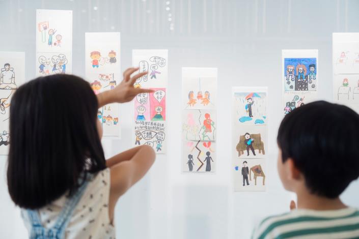 3孩子觀看「一樣不一樣」展中兒童共創作品，透過不同生命經驗與故事，探索差異與共融。透島影業拍攝，桃園市立美術館提供。