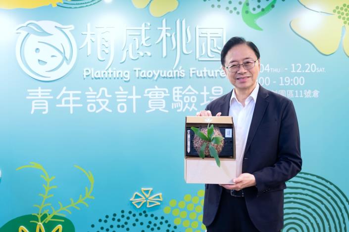 張市長手拿青農設計的植栽作品合影