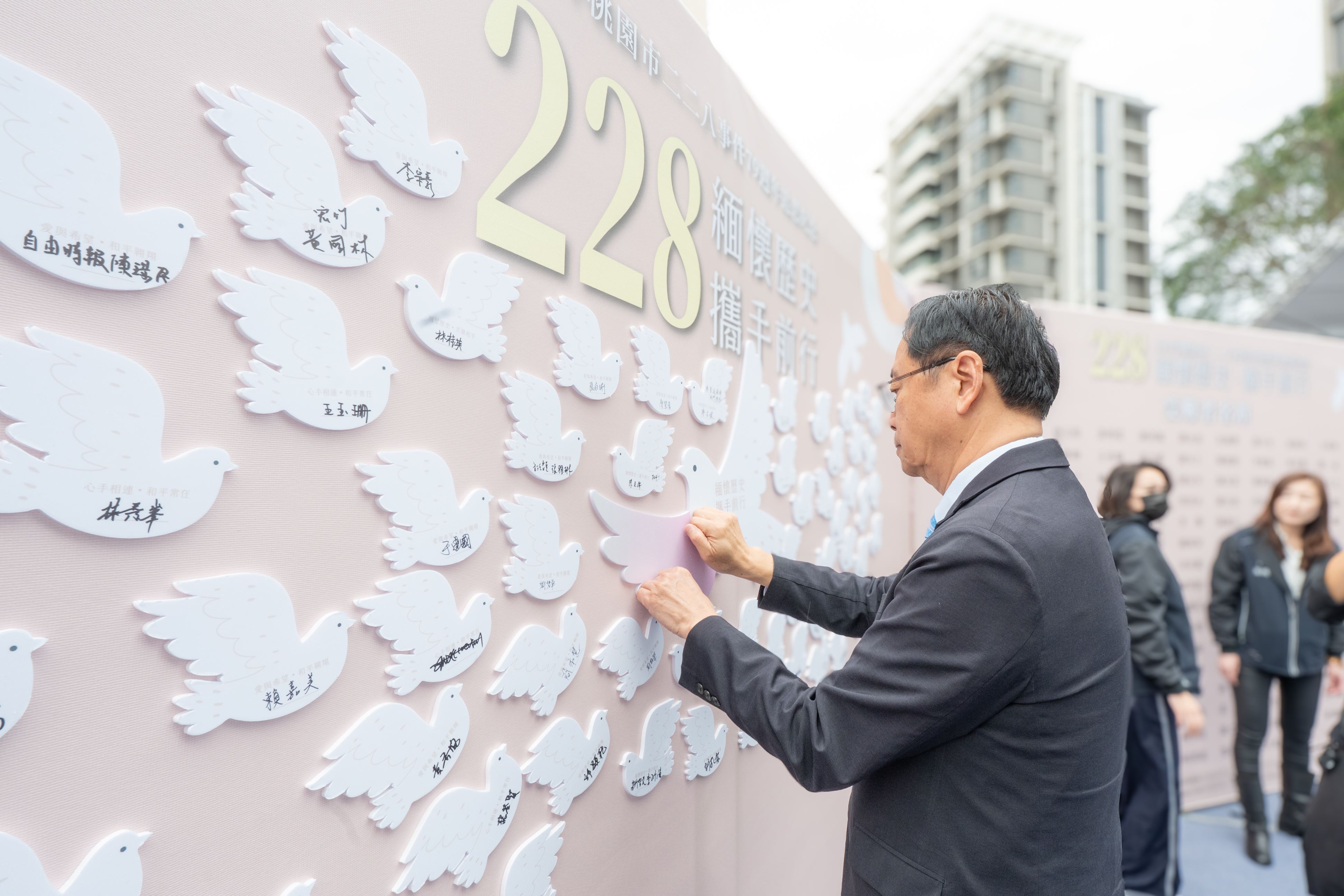 張市長在追思板上貼上象徵自由與祥和的「和平鴿」