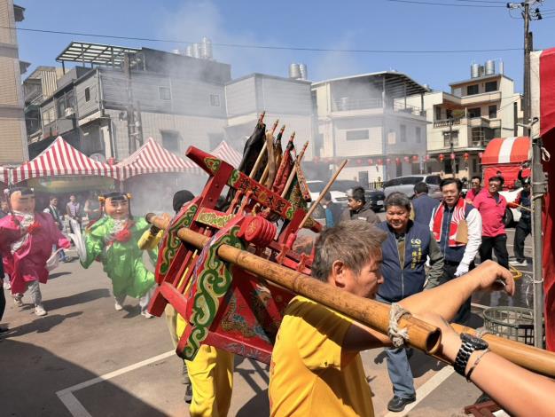 神轎在濃密鞭炮煙硝中前行擺動，象徵為神明準備兵馬糧草，也祈求新的一年平安順遂