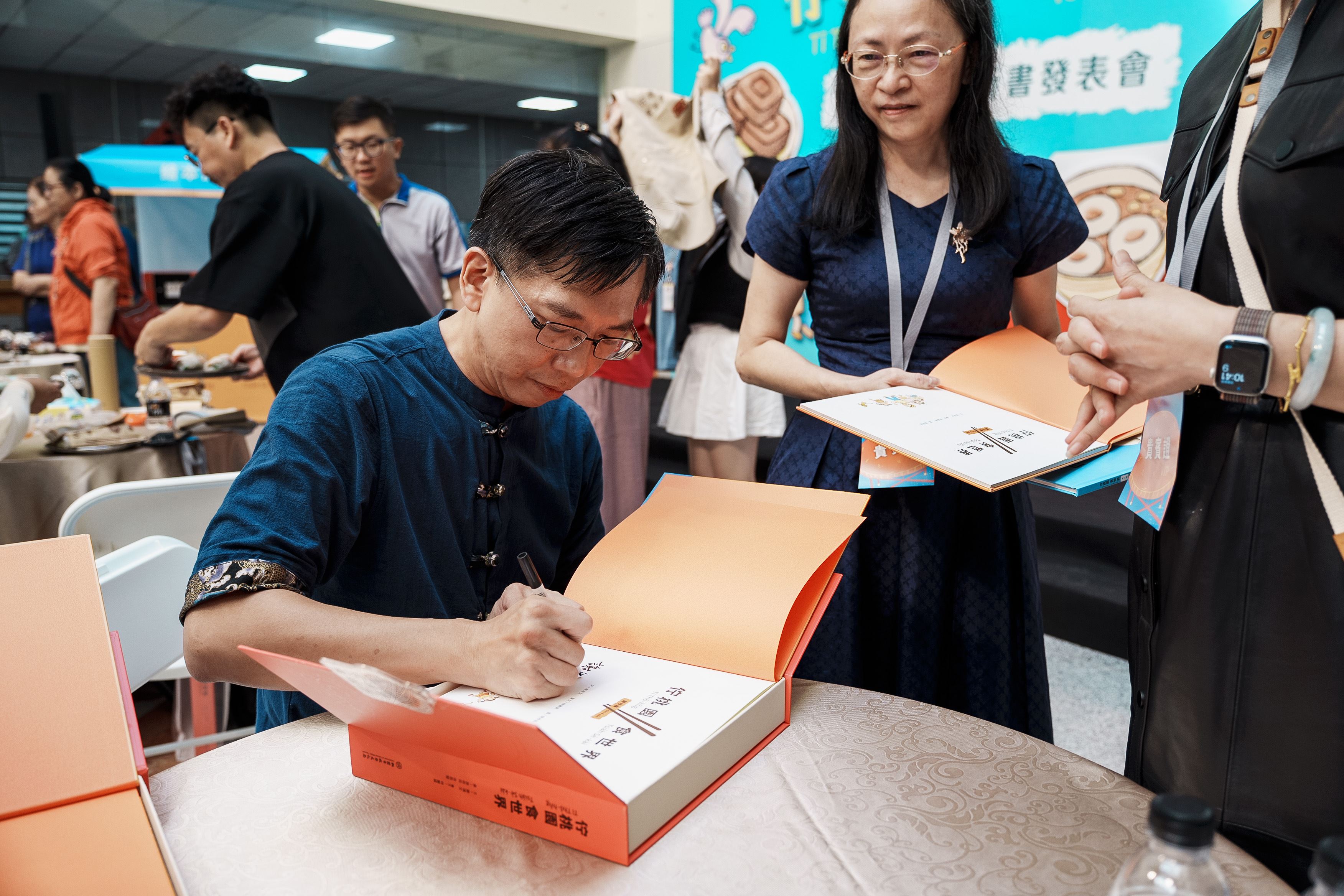  (左起) 謝鴻文老師、錦興國小潘桂芳主任請作家簽名