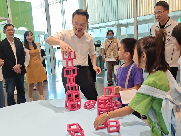 2桃園市副市長蘇俊賓與現場學童共同體驗展覽互動，在遊戲與合作中認識共融的多元樣貌。林家賢攝影，桃園市立美術館提供。