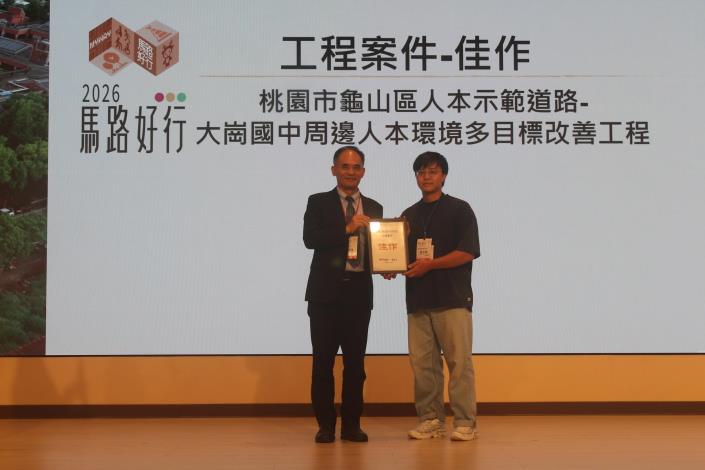 「龜山區人本示範道路大崗國中周邊人本環境多目標改善工程」榮獲佳作獎項(由本處陳俊宏股長(右)領獎)