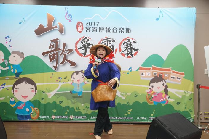 青年組賴多俐打扮成採茶女演唱上山採茶調，為比賽精心設計橋段。