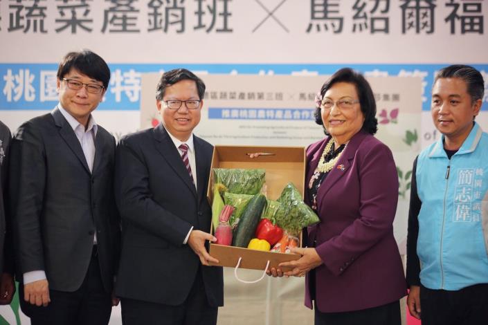 桃園市長鄭文燦(左二)贈給馬紹爾駐台大使艾芮瓊(右二)桃園農特產品。