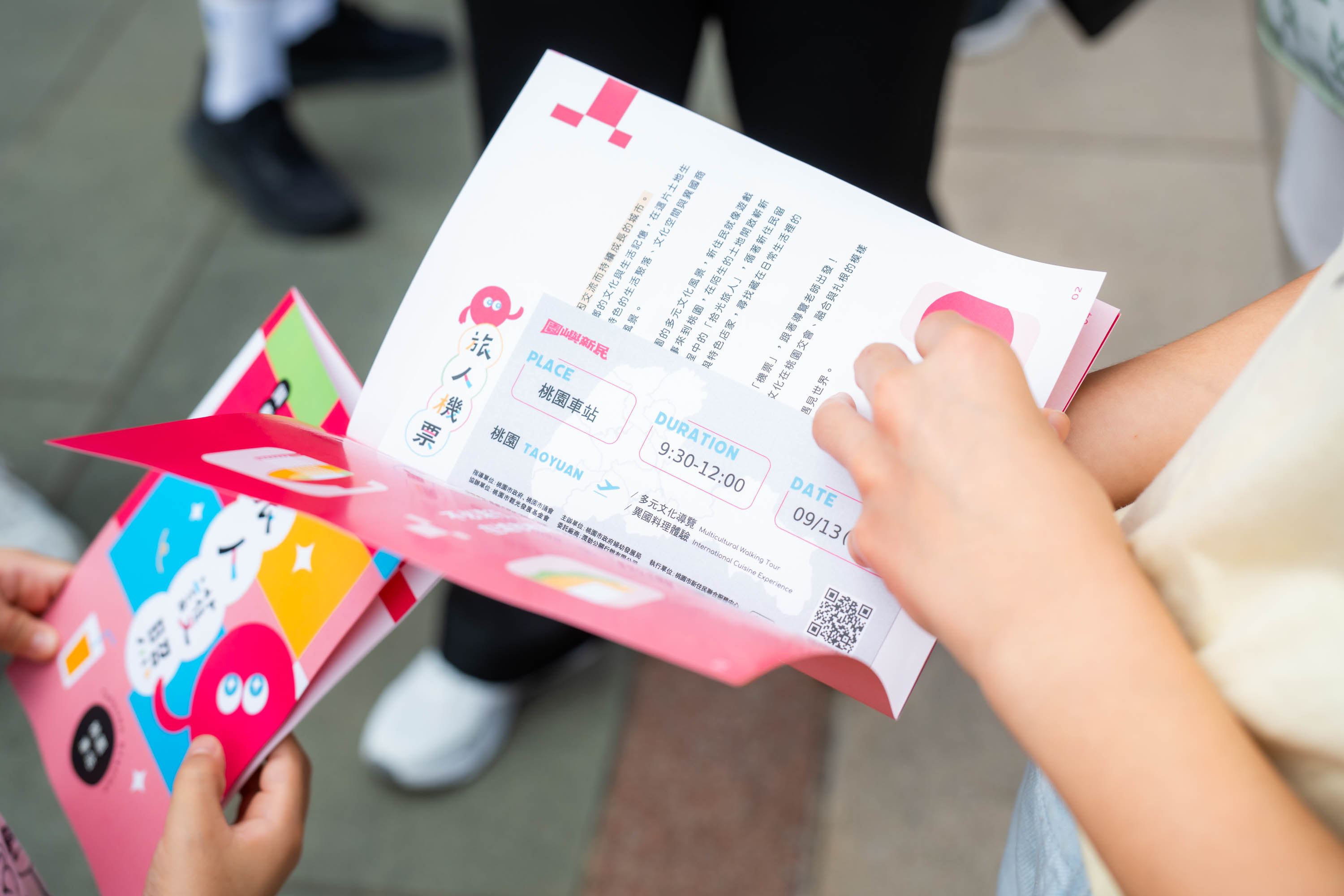 民眾持機票與旅人護照，依導覽地圖展開桃園街區走讀。（圖／桃園市婦幼發展局提供）