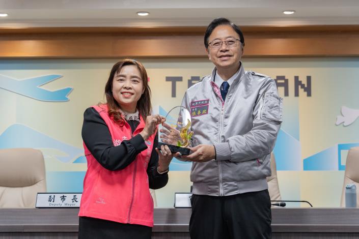 桃園地政所主任游貞蓮代表呈獻衛福部「112年全國績優志工團隊」獎座給張市長