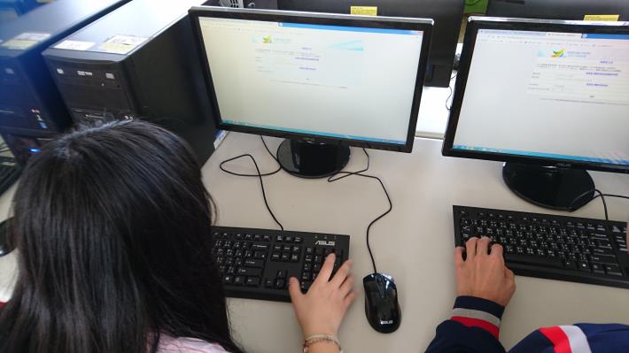 學生在學校電腦教室電腦前查詢放榜資訊
