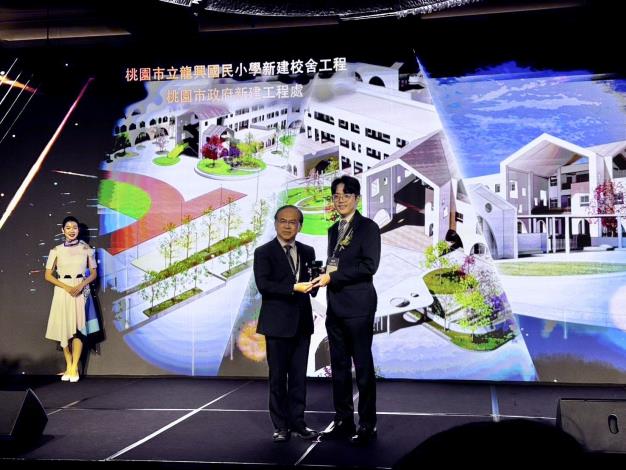 圖6.最佳規劃設計類-卓越獎-桃園市立龍興國民小學新建校舍工程--馮竣蔚-副工程司兼東區工務所主任(右)代表新建工程處領獎