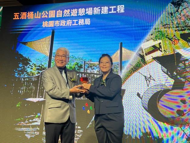 圖10.最佳施工品質類-金質獎-五酒桶山公園自然遊憩場新建工程-陳翠慧科長(右)代表工務局領獎