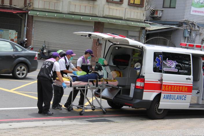 消防人員將患者抬上救護車送醫搶救。