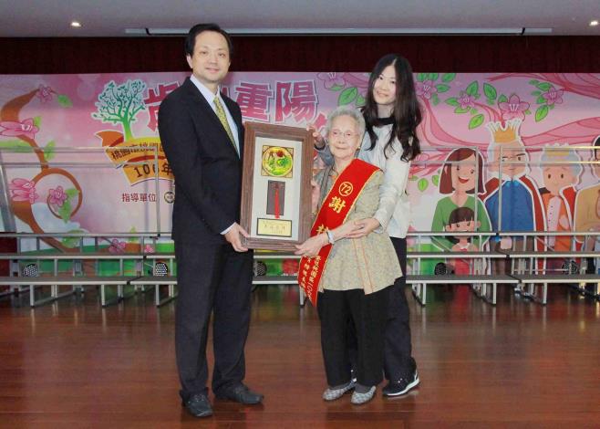 高齡98歲的謝桂女士接受張區長的表揚與祝福。