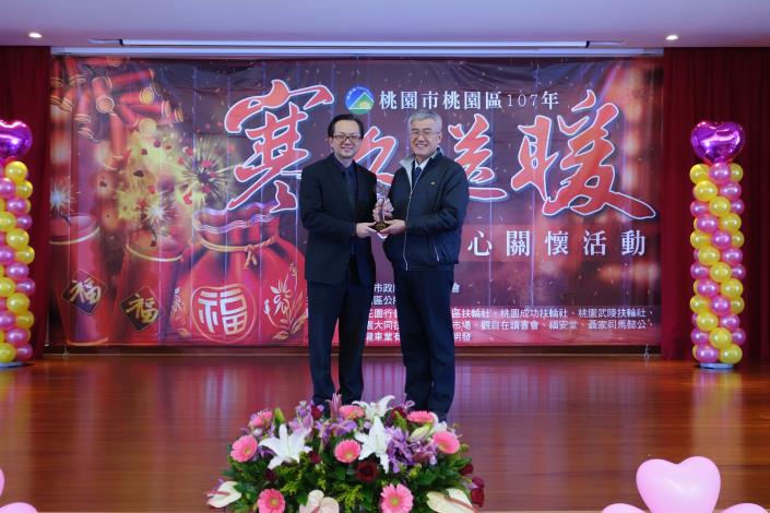 市府秘書長李憲明頒發「熱心公益」獎座，由區長張世威代表桃花園行善團領獎。