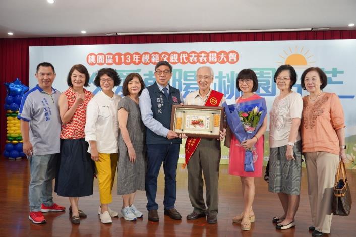 許區長頒獎予全場最年長受獎人並合影。
