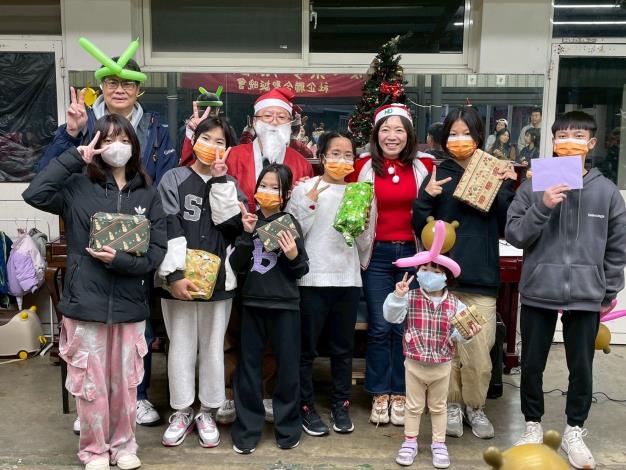 活動中，局長與企業夥伴致贈聖誕禮物並與孩童合影，記錄節慶陪伴的溫馨時刻，呈現企業資源導入、社企專業參與的公益服務現場。